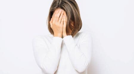 Mujer triste y agobiada que se tapa la cara con las manos. Mujer triste y agobiada que se tapa la cara con las manos.